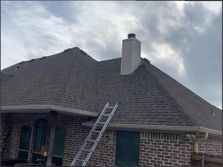 Roof repair in progress on a Tulsa-area home, ladder set against fresh gray shingles